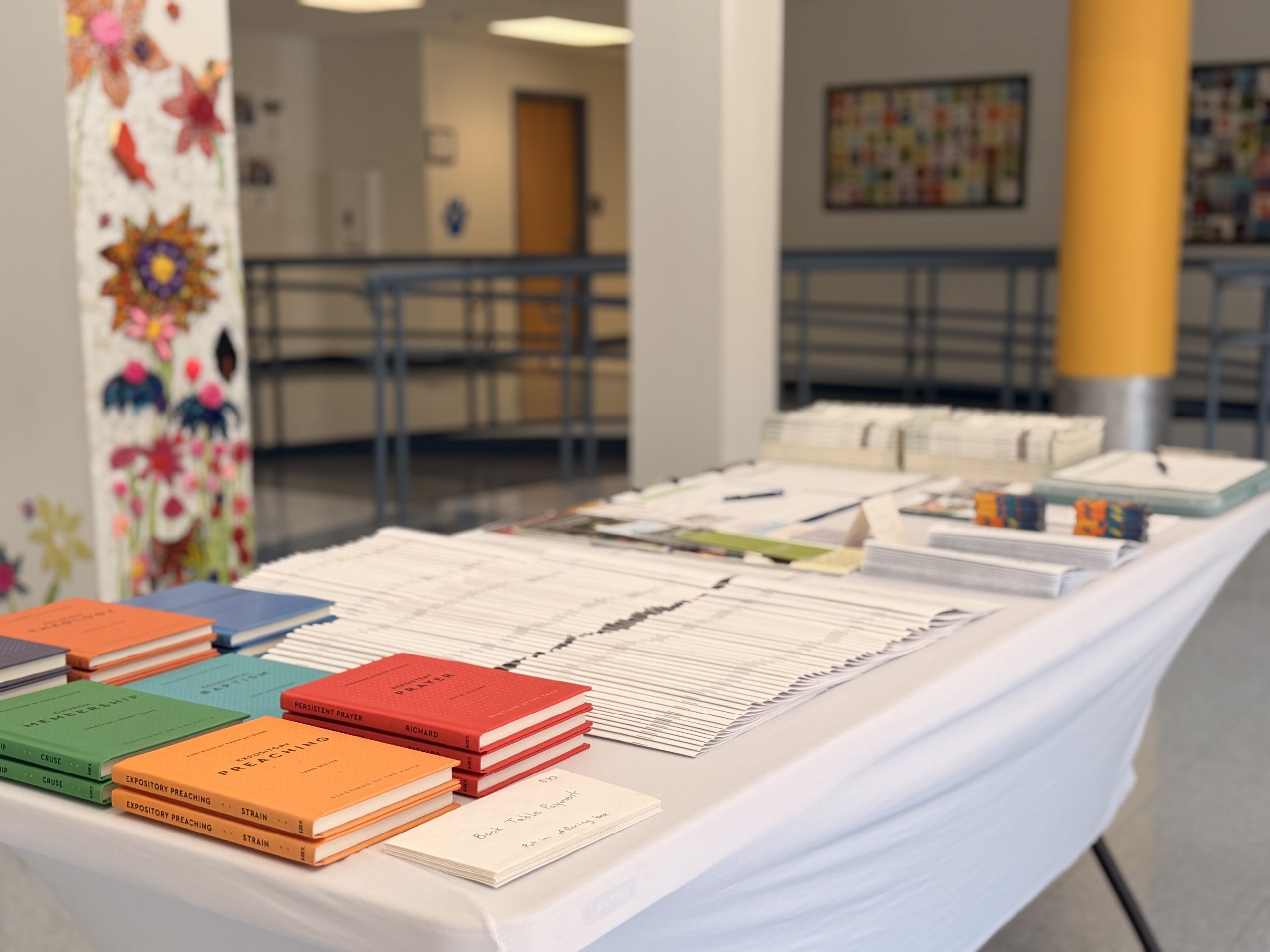 Welcome table with books and bulletins in the school hallway